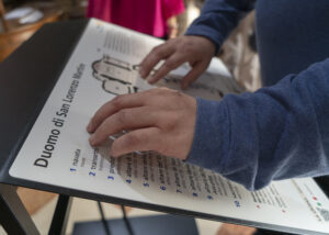 mani che toccano il pannello multisensoriale del Duomo di Mestre